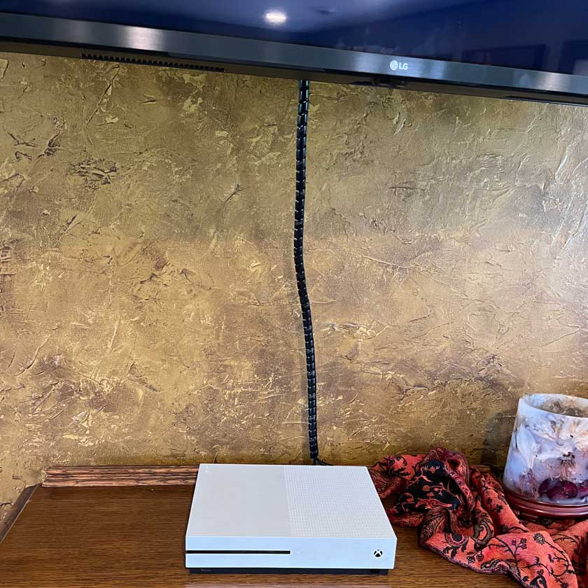 Green Snakelet Wrap hides tv wires dangling down the wall from the tv to the cable box.